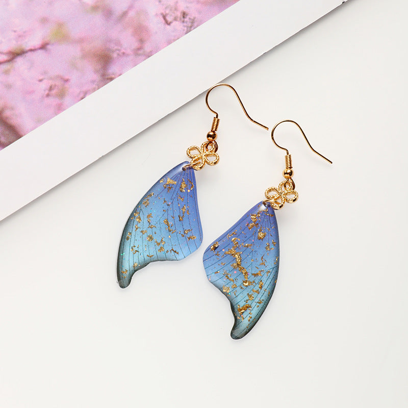 Brincos coloridos de epóxi em folha de ouro com asas de borboleta